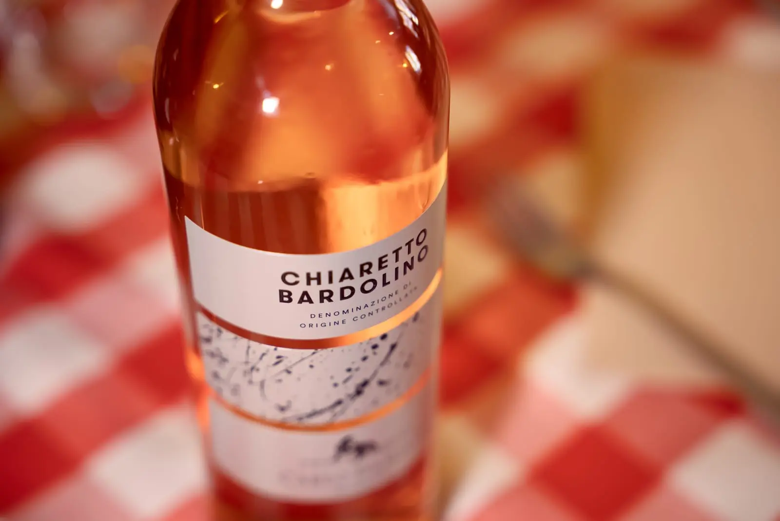Bouteille de Chiaretto di Bardolino sur la nappe vichy · cave Little Italy Menton
